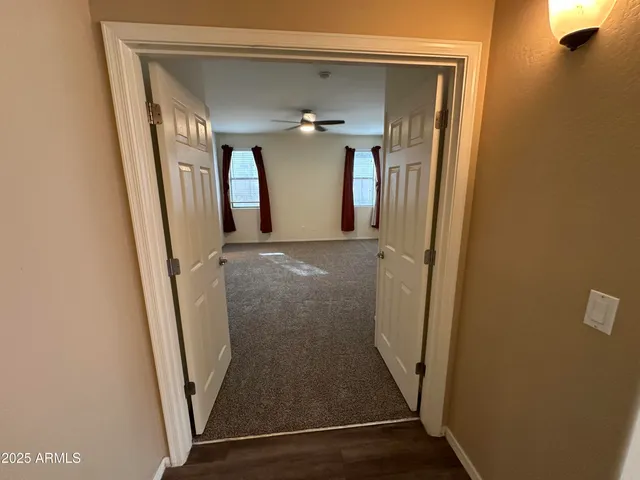 a view of a living room a wooden floor and a ceiling fan