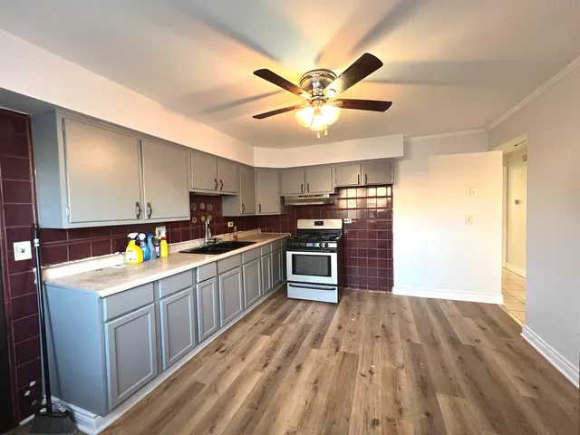 a kitchen with a sink window and stainless steel appliances
