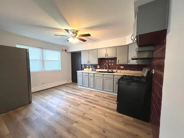 a kitchen with a sink a stove and cabinets
