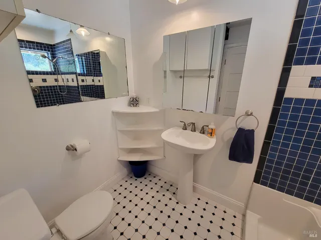 a bathroom with a sink toilet a mirror and shower