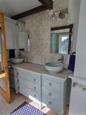 a bathroom with a granite countertop sink vanity mirror and bathtub