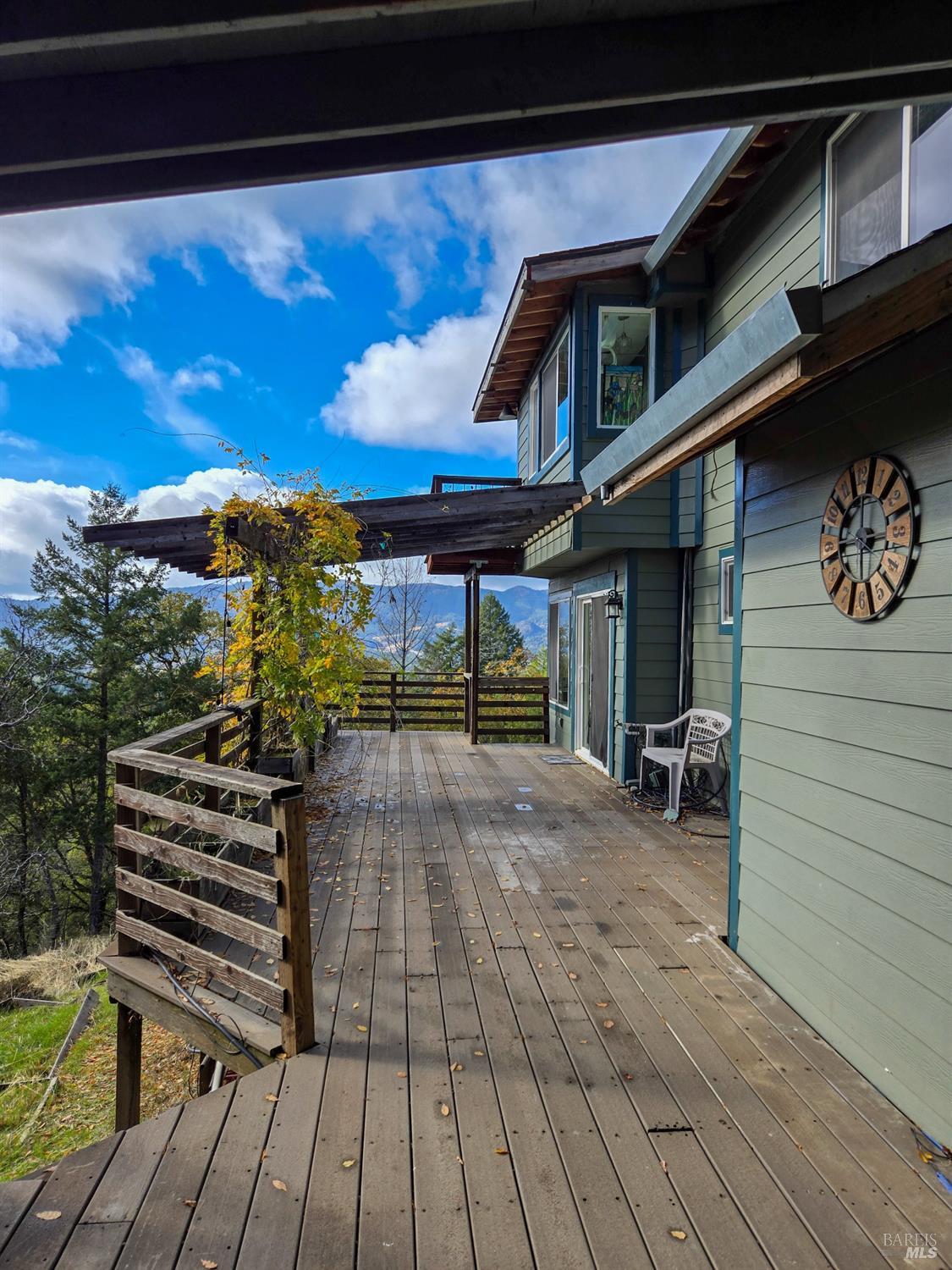 47111 Fox Rock Road Laytonville, CA 95454 - Photo 4 of 44 a view of a patio with a table and chairs under an umbrella with wooden floor