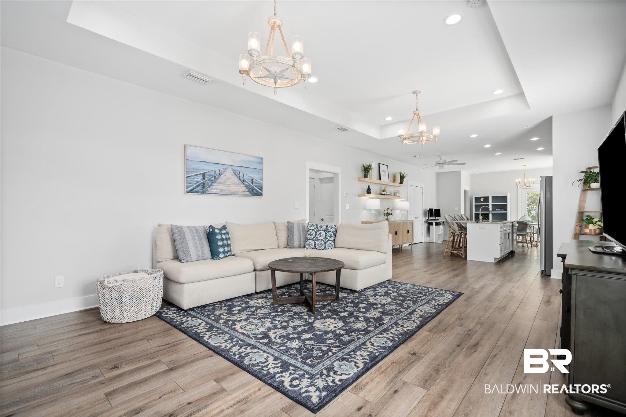 8056 Carmel Circle Foley, AL 36535 - Photo 3 of 28 Living room with wood-type flooring, a chandelier, and a tray ceiling