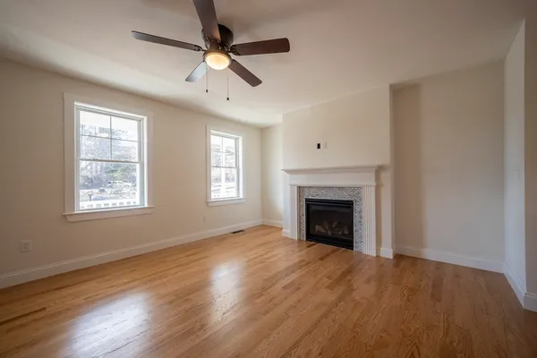 an empty room with windows fireplace and a sink