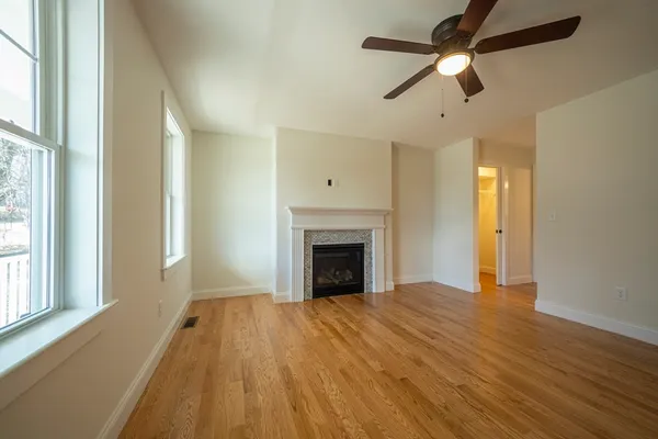 a view of an empty room with a fireplace and a window