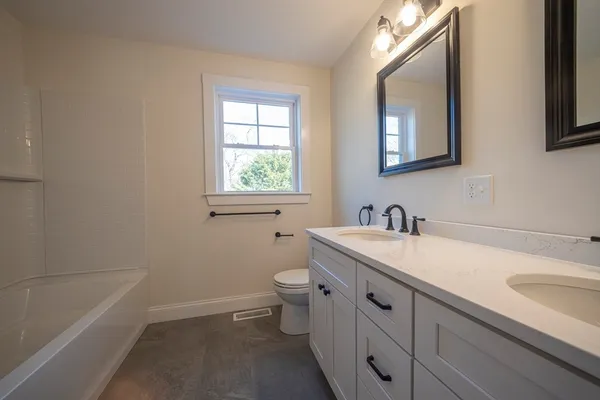 a bathroom with a sink toilet vanity and bathtub