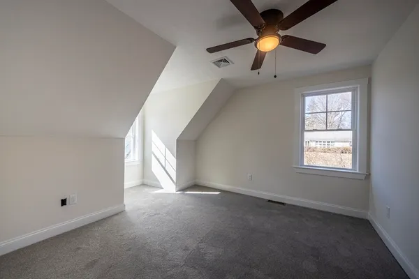 an empty room with a window and a fan