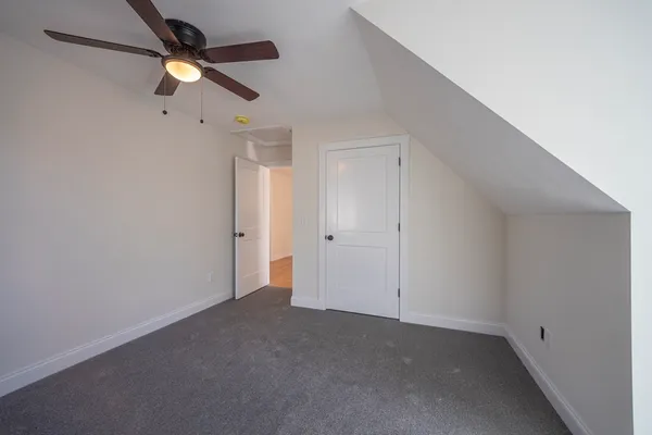 an empty room with a ceiling fan and a window