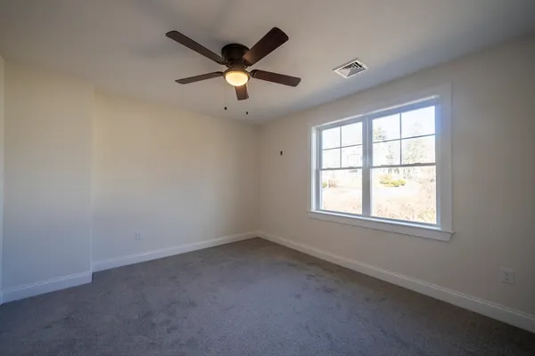 an empty room with a window and a fan