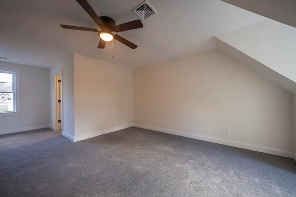 an empty room with a ceiling fan and a window