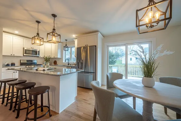 a kitchen with kitchen island a table and chairs in it