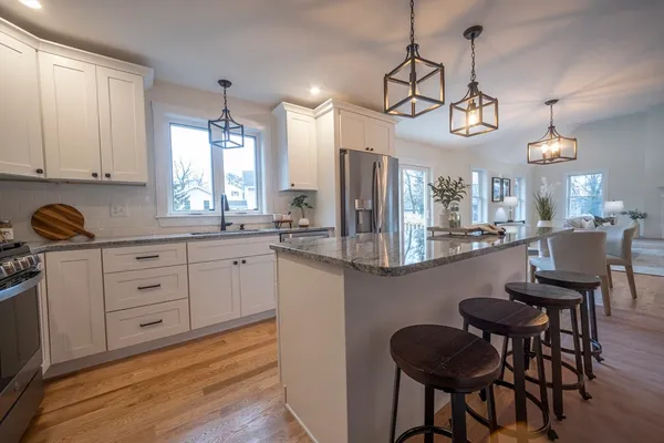 a kitchen with a dining table chairs sink and cabinets