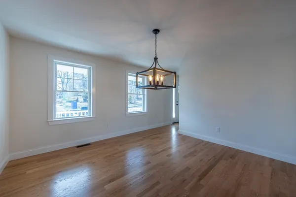 a view of wooden floor windows and chandelier in a room