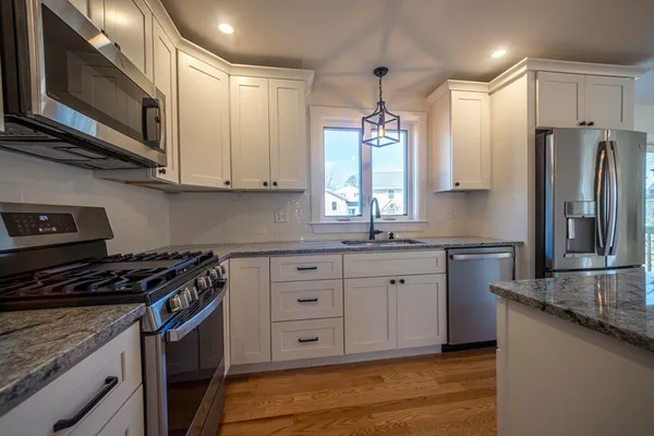 a kitchen with stainless steel appliances granite countertop a sink stove and cabinets