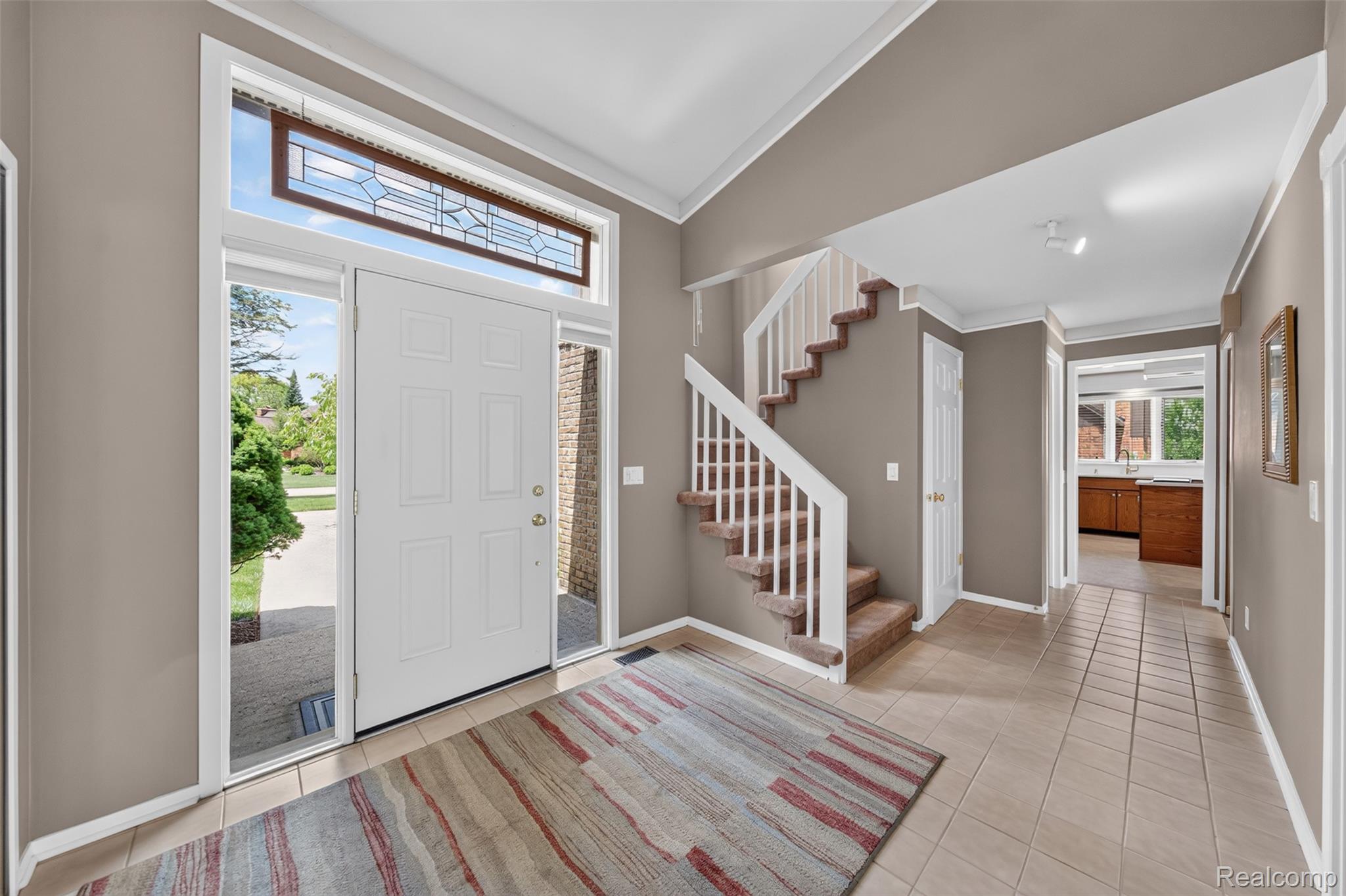 1236 Chaffer Drive Rochester, MI 48306 - Photo 6 of 76 Entryway featuring a white paneled front door with sidelights, a decorative transom window, and tile flooring