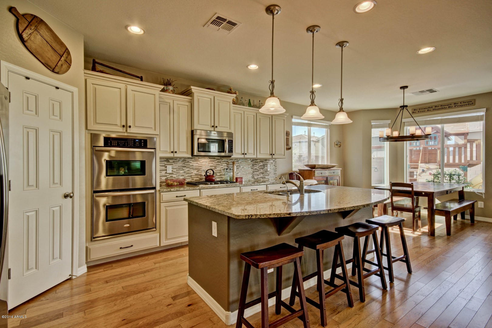 2280 North Alsap Road Buckeye, AZ 85396 - Photo 21 of 65 a kitchen with stainless steel appliances kitchen island granite countertop a stove a sink and a refrigerator