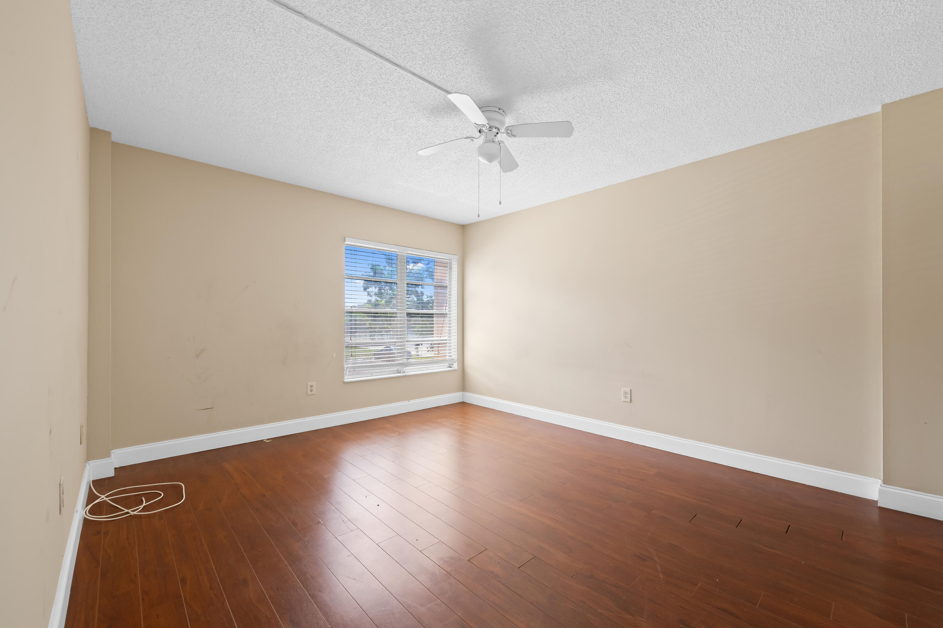 4156 Inverrary Drive, Unit 210 Lauderhill, FL 33319 - Photo 11 of 27 an empty room with wooden floor fan and windows