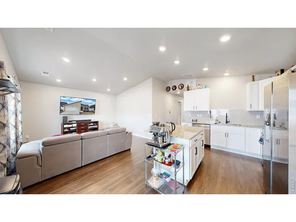 a living room with stainless steel appliances kitchen island furniture and a view of kitchen