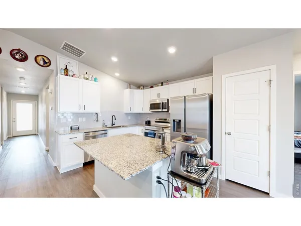 a living room with stainless steel appliances kitchen island granite countertop furniture and a view of kitchen