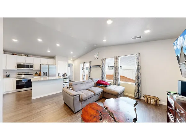 a living room with furniture and kitchen view