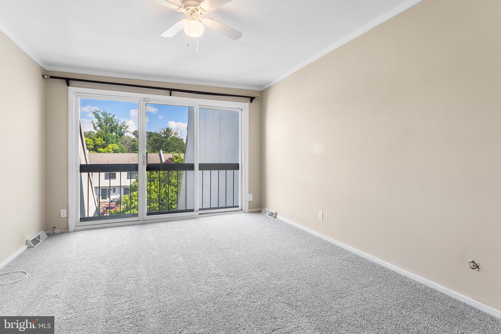 625 Summit House West Chester, PA 19382 - Photo 8 of 16 an empty room with large windows and a ceiling fan