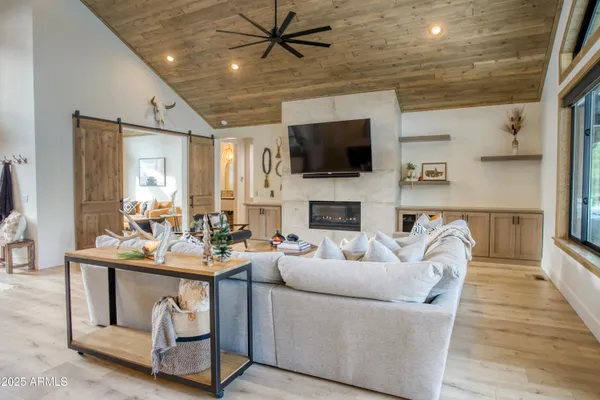 a living room with furniture a fireplace and a flat screen tv