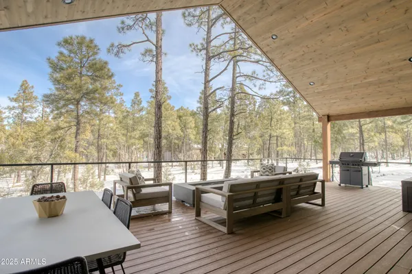 a roof deck with couches and wooden floor