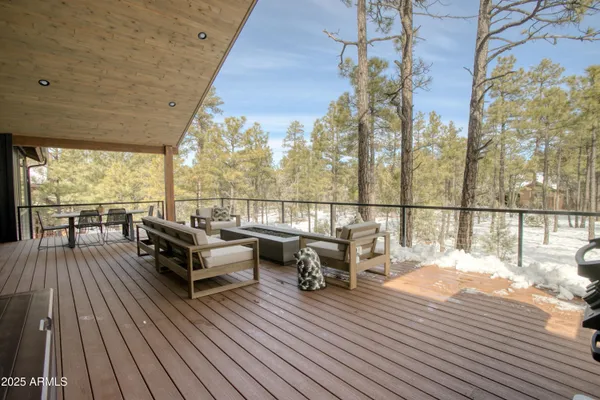 a view of a roof deck with couches and wooden floor