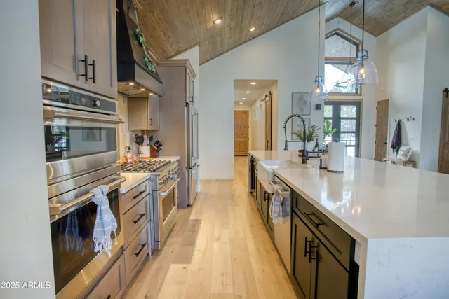 a kitchen with stainless steel appliances granite countertop lots of counter top space and wooden floor