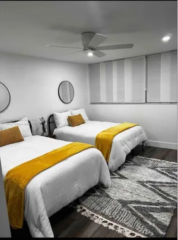 a bedroom with two beds and wooden floor