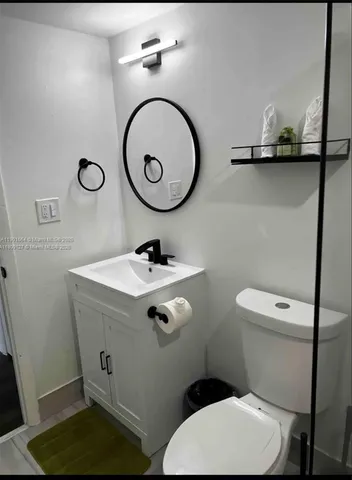 a bathroom with a toilet a sink and a mirror