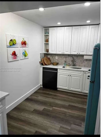 a kitchen with a refrigerator and a sink