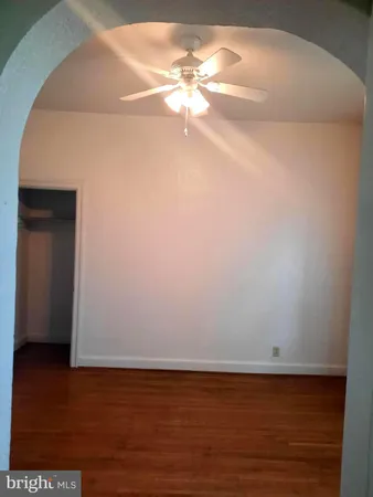 a view of a room with wooden floor and fan