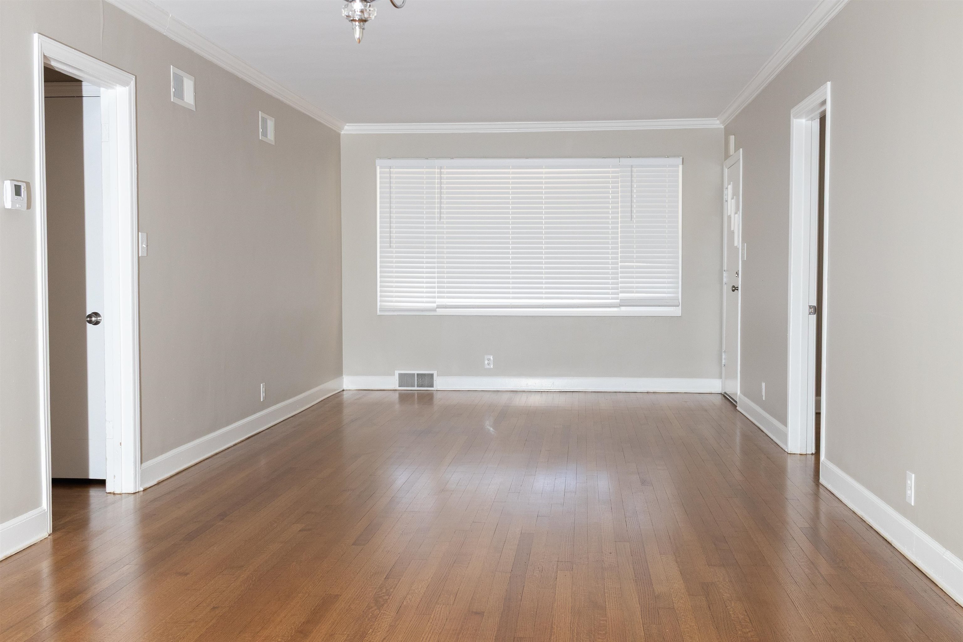 1050 Marcia Road Memphis, TN 38117 - Photo 5 of 20 an empty room with wooden floor and windows