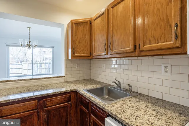 a kitchen with granite countertop cabinets sink and window