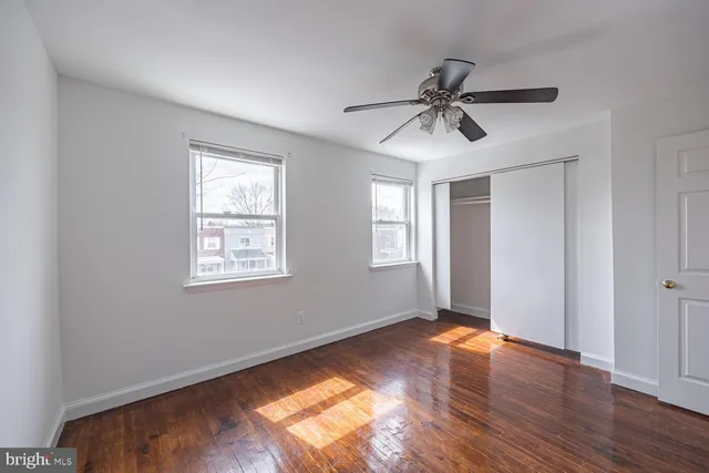 a view of a livingroom with a window and wooden floor