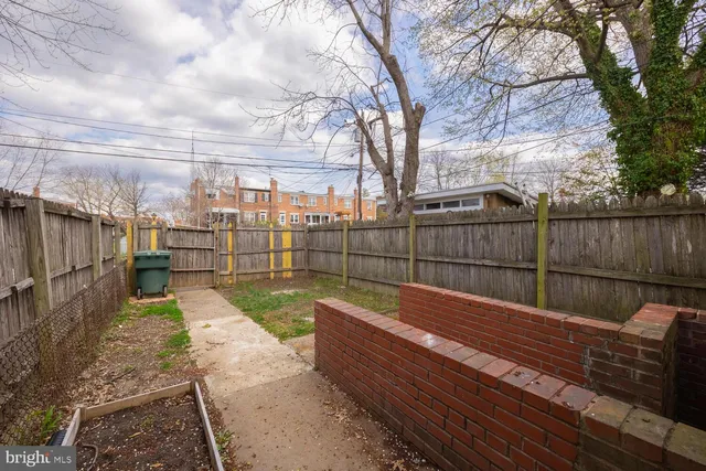 a view of a backyard with wooden fence