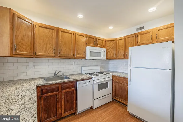 a kitchen with a sink a refrigerator and cabinets