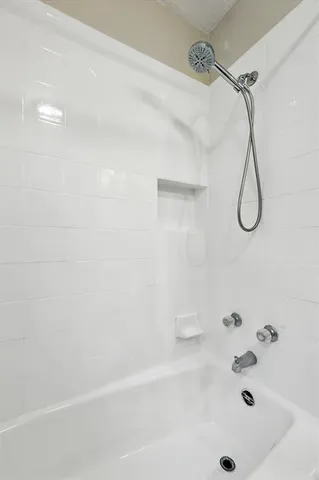 a bathroom with a bath tub with a shower
