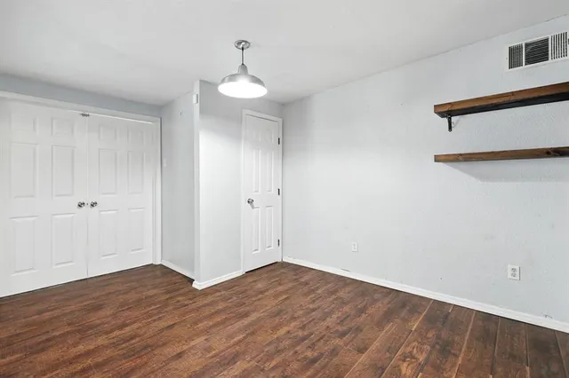 a view of a room with wooden floor and white walls