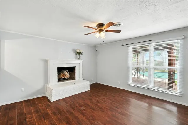 a view of an empty room with exposed radiator and fireplace