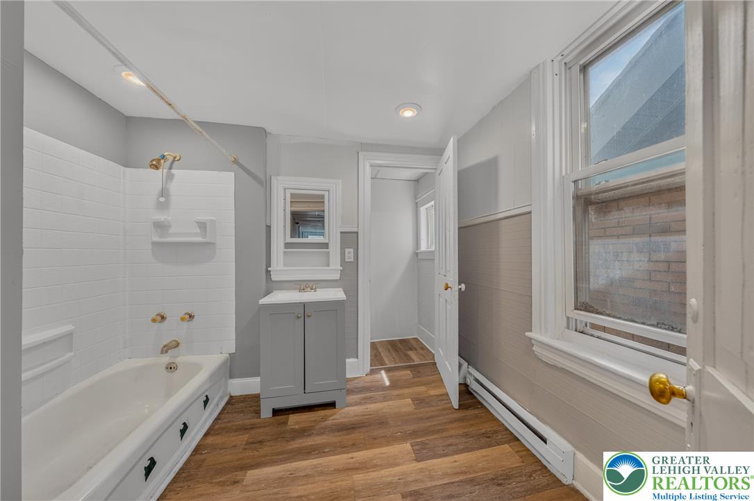 313 Main Street Slatington, PA 18080 - Photo 41 of 73 Step into a well-lit bathroom featuring a tub and a sleek vanity with modern flooring.