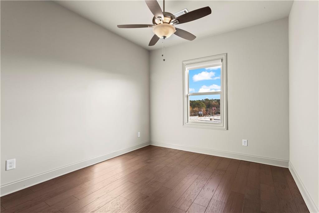 1892 Skyfall Circle Brookhaven, GA 30319 - Photo 19 of 24 an empty room with wooden floor ceiling fan and windows