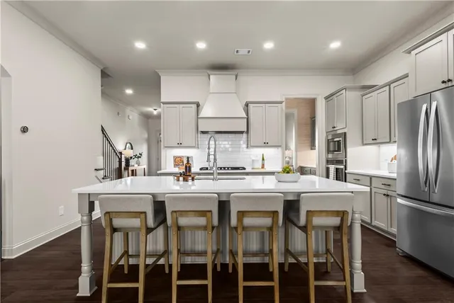 a kitchen with stainless steel appliances a dining table and chairs