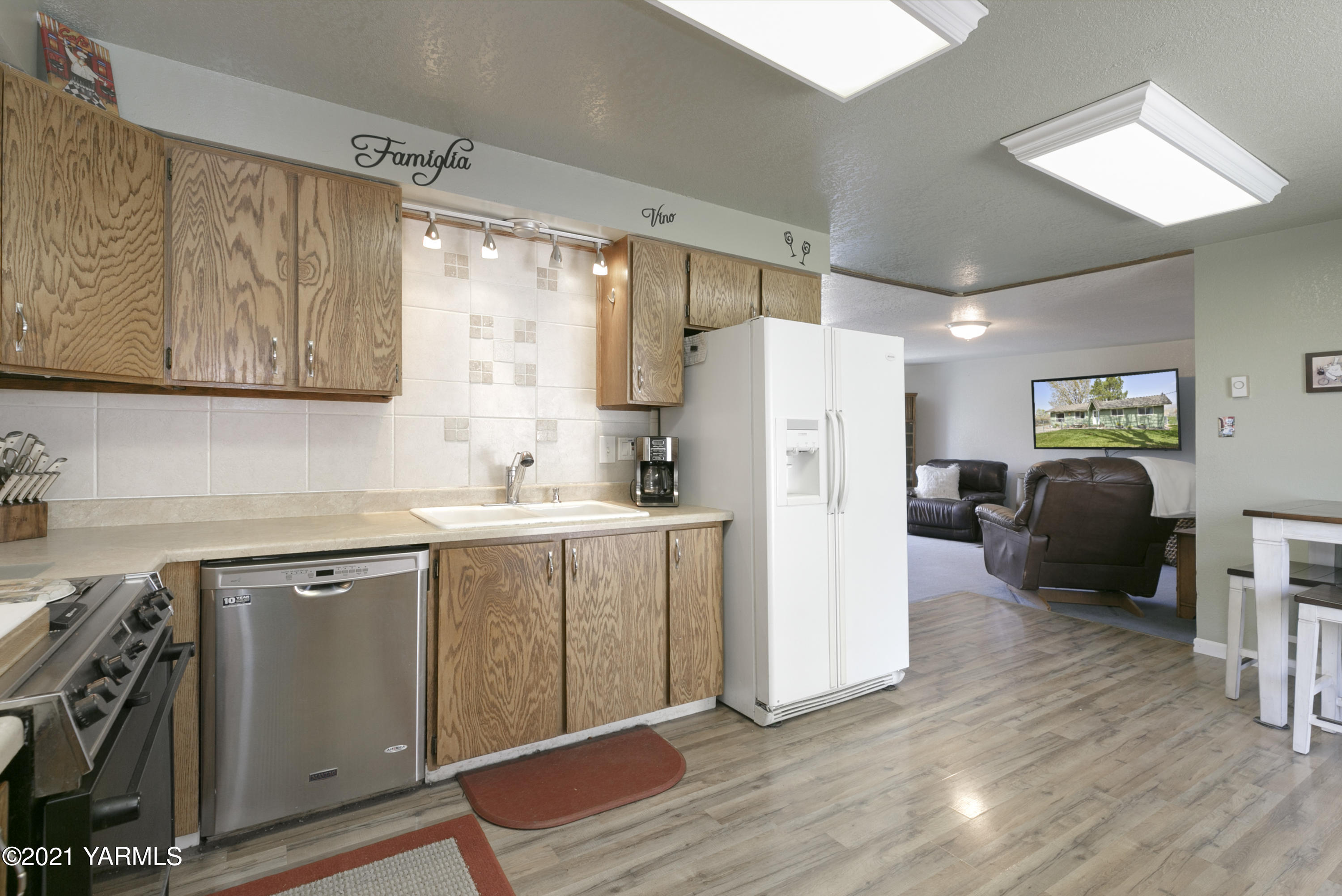 1111 Deeringhoff Road Moxee, WA 98936 - Photo 10 of 18 a kitchen with a refrigerator sink and cabinets