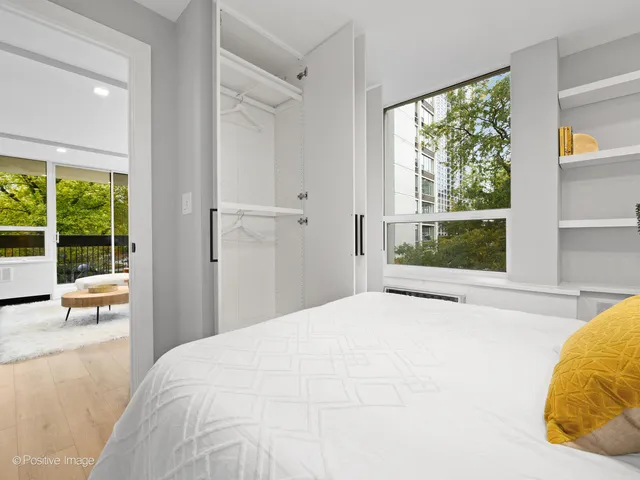 a bedroom with a bed and large windows