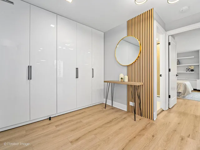 a view of a room with wooden floor mirror and windows