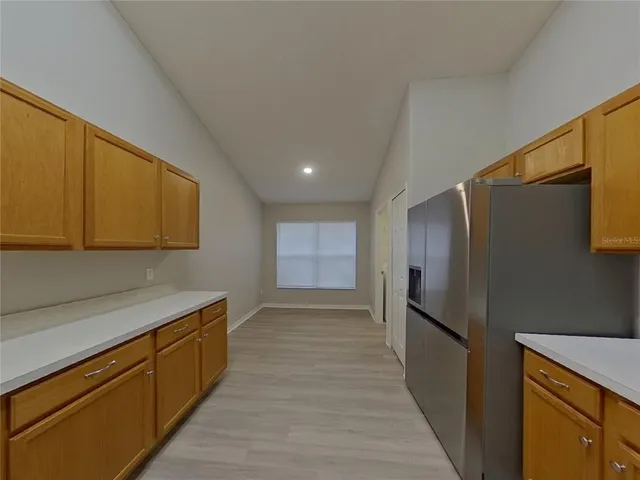 a kitchen with stainless steel appliances granite countertop a refrigerator and a sink