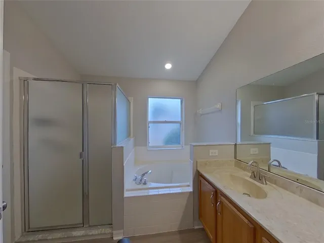 a bathroom with a granite countertop bathtub sink vanity and mirror