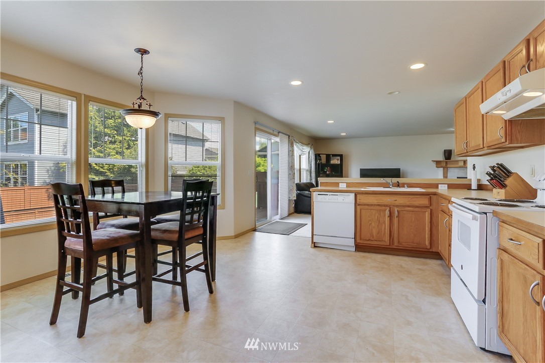 2310 Southeast 3rd Street Renton, WA 98056 - Photo 11 of 30 a kitchen with a table chairs refrigerator and cabinets